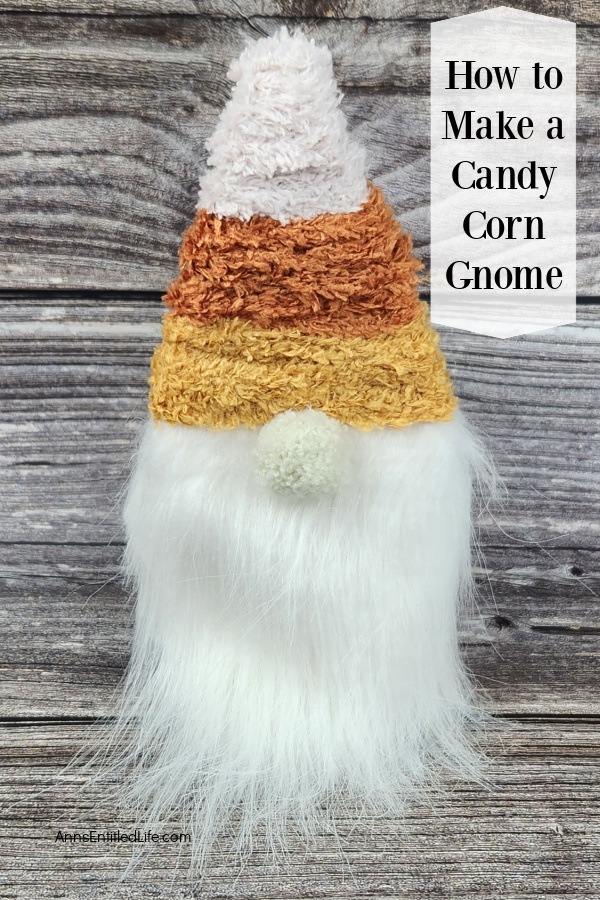 a candy corn gnome set against a grey background