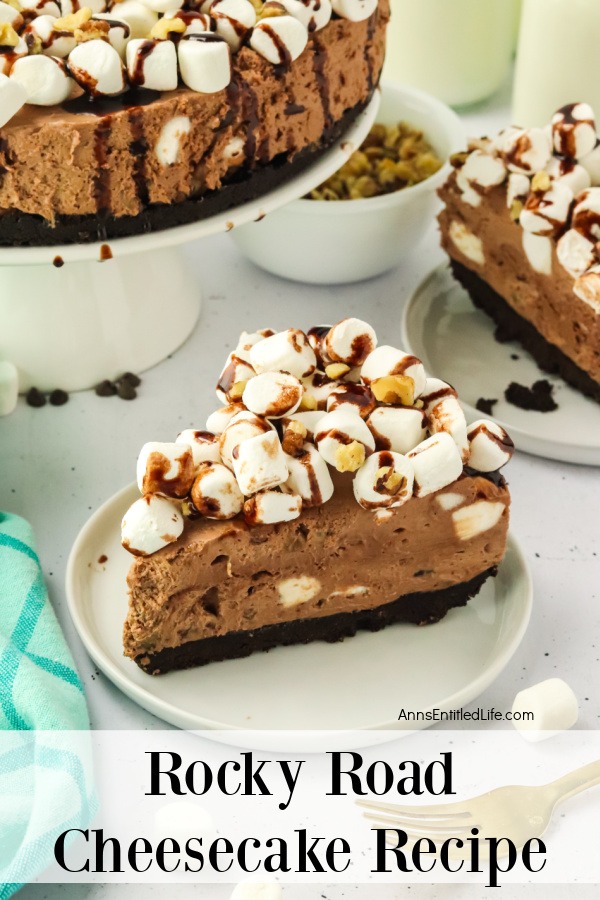 A piece of no-bake rocky road cheesecake on a white plate, the rest of the cheesecake can be partially seen in the upper left, another piece is in the upper right