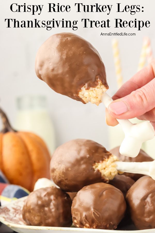 A woman is holding a rice crispy cereal turkey leg up from the plate full of more of those treats below.