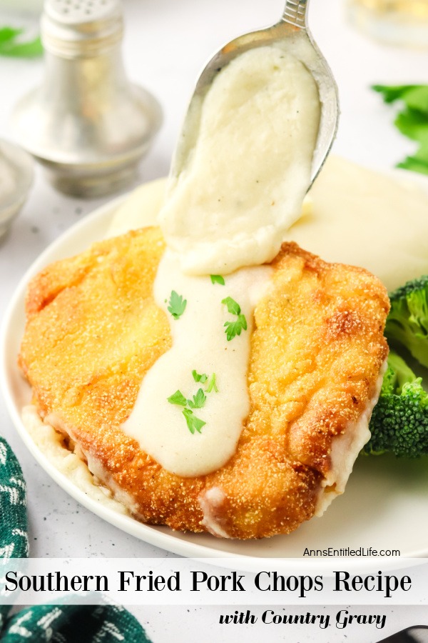 A white plate is filled with southern fried pork chop, broccoli and mashed potatoes. A spoon is drizzling gravy on top of the pork chop.