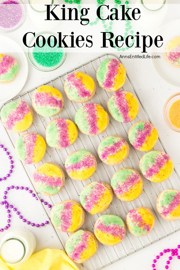 An overhead view of a wire rack filled king cake cookies surrounded by colored sugar and mardi gras beads
