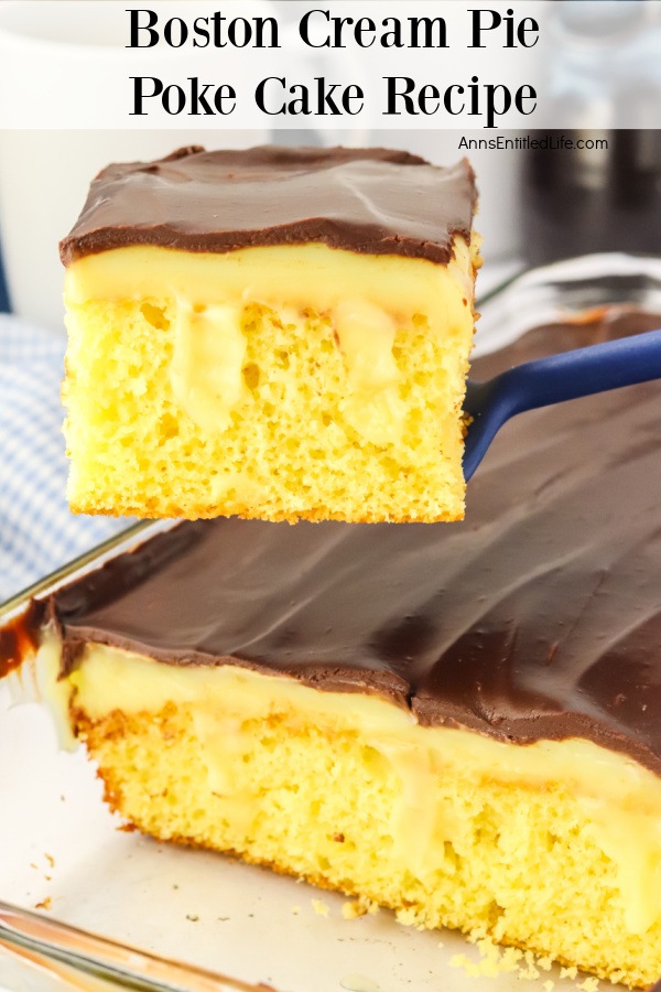 A piece of Boston vream pie poke cake is being lifted from the whole cake below