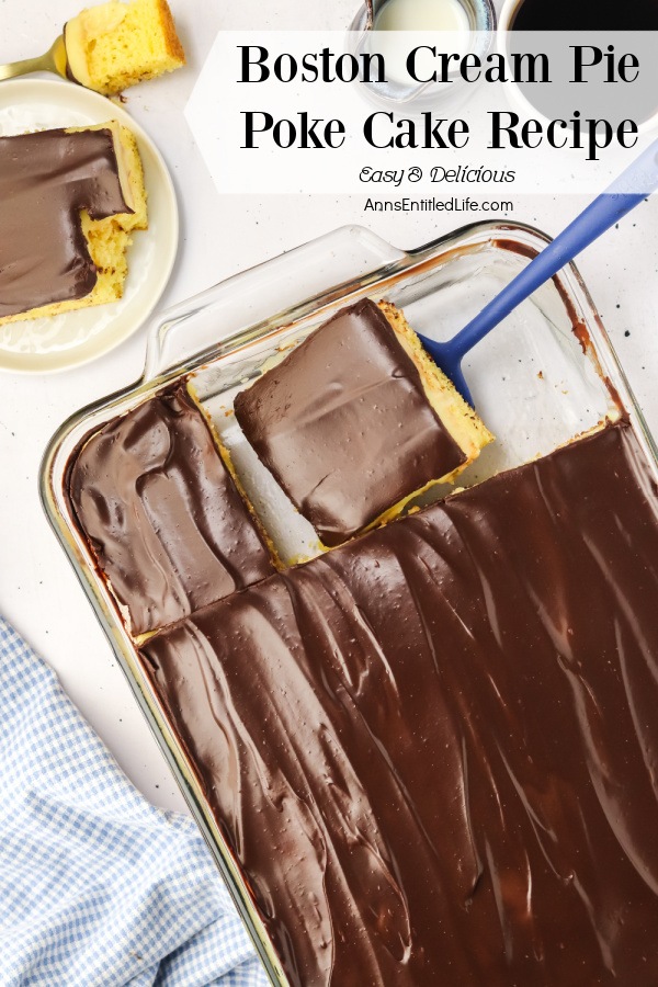 Overhead view of a Boston cream pie poke cake in a glass 13x9 pan with one piece removed, a second being lifted from the pan. The removed piece is on a white plate in the upper left. There is a cup of black coffee in the upper right.