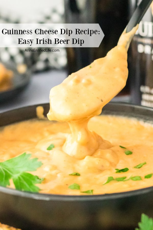 A black bowl filled with Guinness cheese dip, a spoonful of the dip is being lifted from the bowl.
