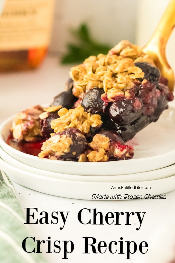 A servings of cherry crisp is being spooned into a shallow white bowl