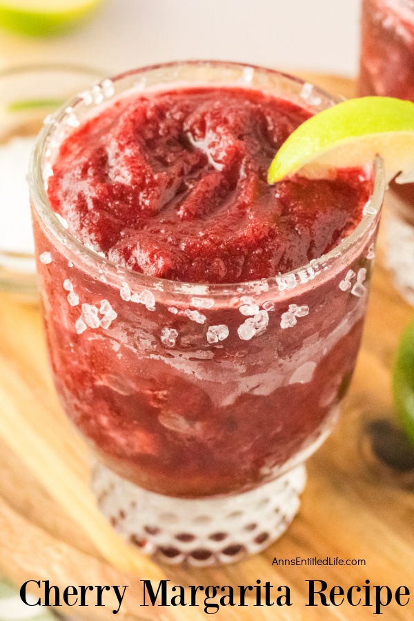 Overhead photo of a frozen cherry margarita in a msall cocktail glass sitting on a cutting board
