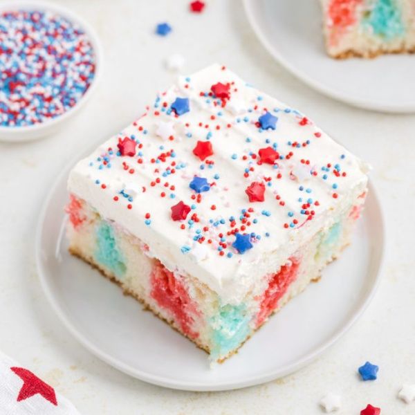 Easy 4th of July Jello Poke Cake is a festive red, white, and blue dessert! A moist white cake poked with cherry and berry Jell-O, topped with whipped topping and sprinkles. The perfect make-ahead treat for your Independence Day celebration!