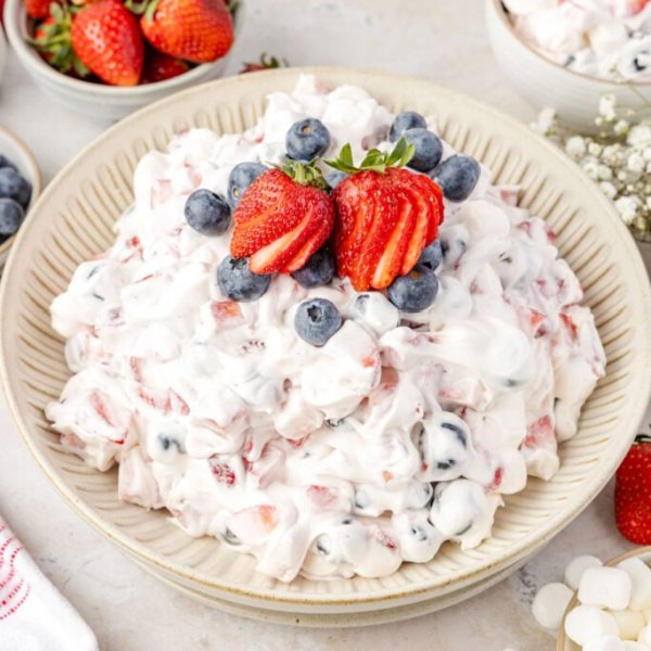 Red, White & Blue Cheesecake Salad – the easiest, most delicious patriotic side dish! Creamy cheesecake fluff loaded with fresh berries for your 4th of July party.