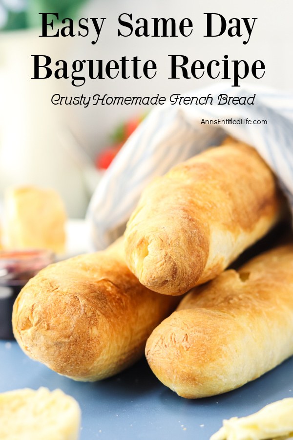 Three homemade French baguettes wrapped in a dishtowel on a blue surface.