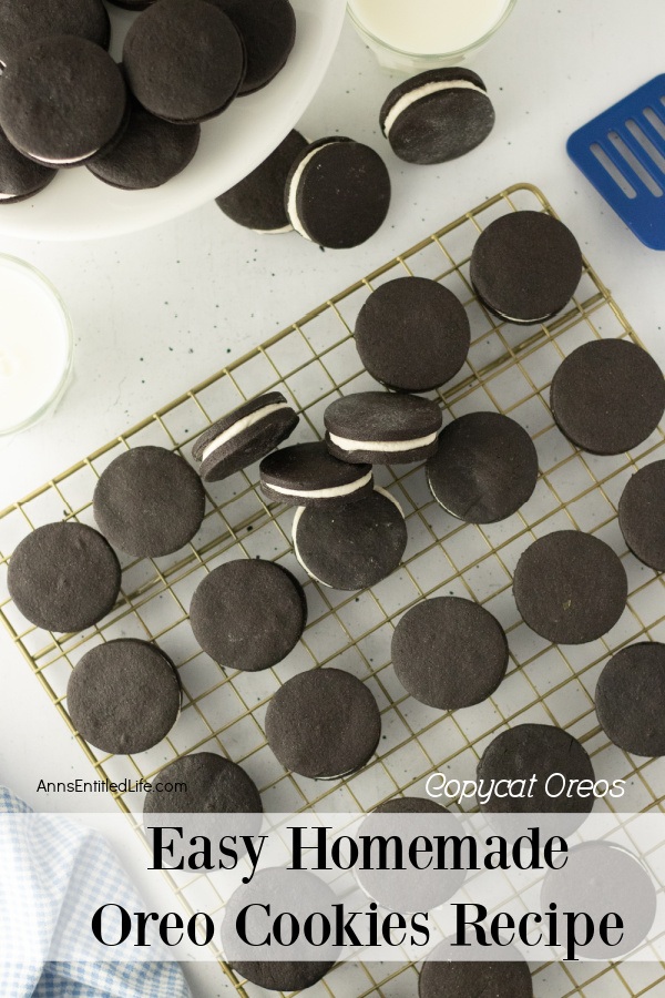 Overhead view of homemade Oreo cookies on a wire cooling rack. There is a cake plate filled with homemade Oreo cookies in the upper left, as well as some cookies on the cupboard surface.