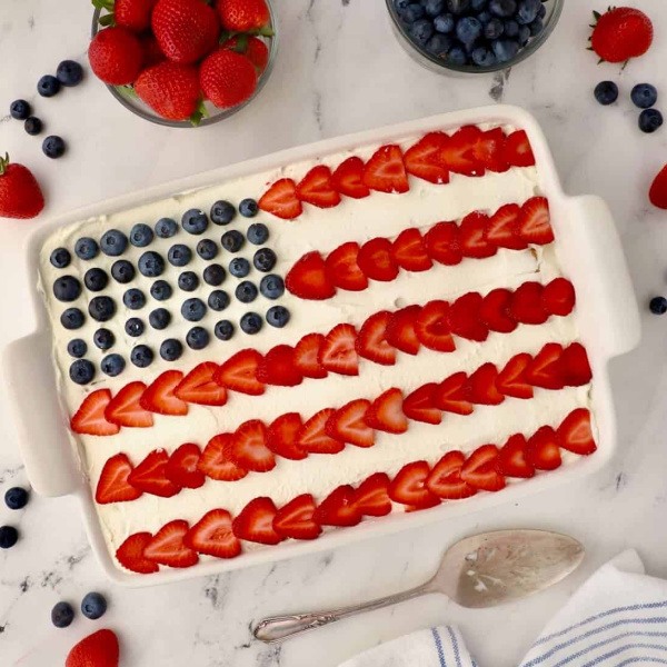 Easy Red, White, and Blue No-Bake Icebox Cake is the ultimate patriotic dessert! Layers of graham crackers, fluffy whipped cream, fresh strawberries, and blueberries create a cool, creamy treat perfect for 4th of July.