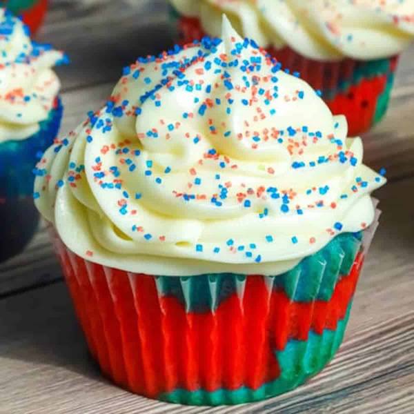 Easy Red, White, and Blue Cupcakes are the ultimate patriotic dessert! Moist swirled red, white, and blue vanilla cupcakes topped with white frosting and festive sprinkles. Perfect for 4th of July!
