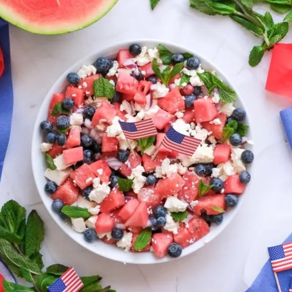 This vibrant Patriotic Watermelon Feta Salad is the ultimate refreshing side dish for your America 250 party or July 4, 2026 picnic. Juicy watermelon cubes, creamy feta cheese, sweet blueberries, fresh mint, and a light olive oil dressing create a stunning red, white, and blue presentation that tastes as good as it looks.